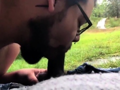 Bearded bear sucks black cock outdoor